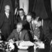 FBI Director J. Edgar Hoover stands behind President Franklin Delano Roosevelt and watches him sign a bill to enforce the fight against crime.